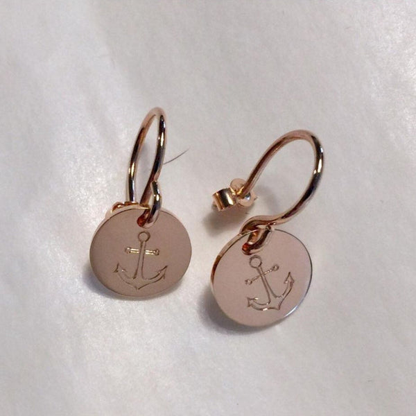 Rose gold earrings with anchor design on a white background