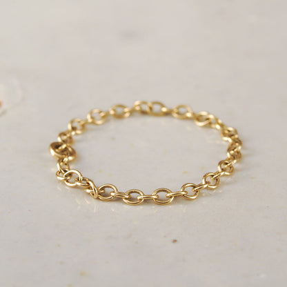 Gold chain ring on a light gray background