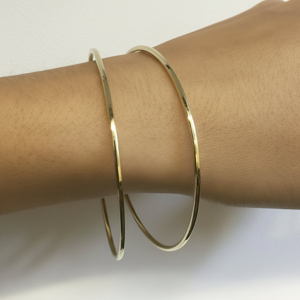 yellow gold hammered bangles on the wrist