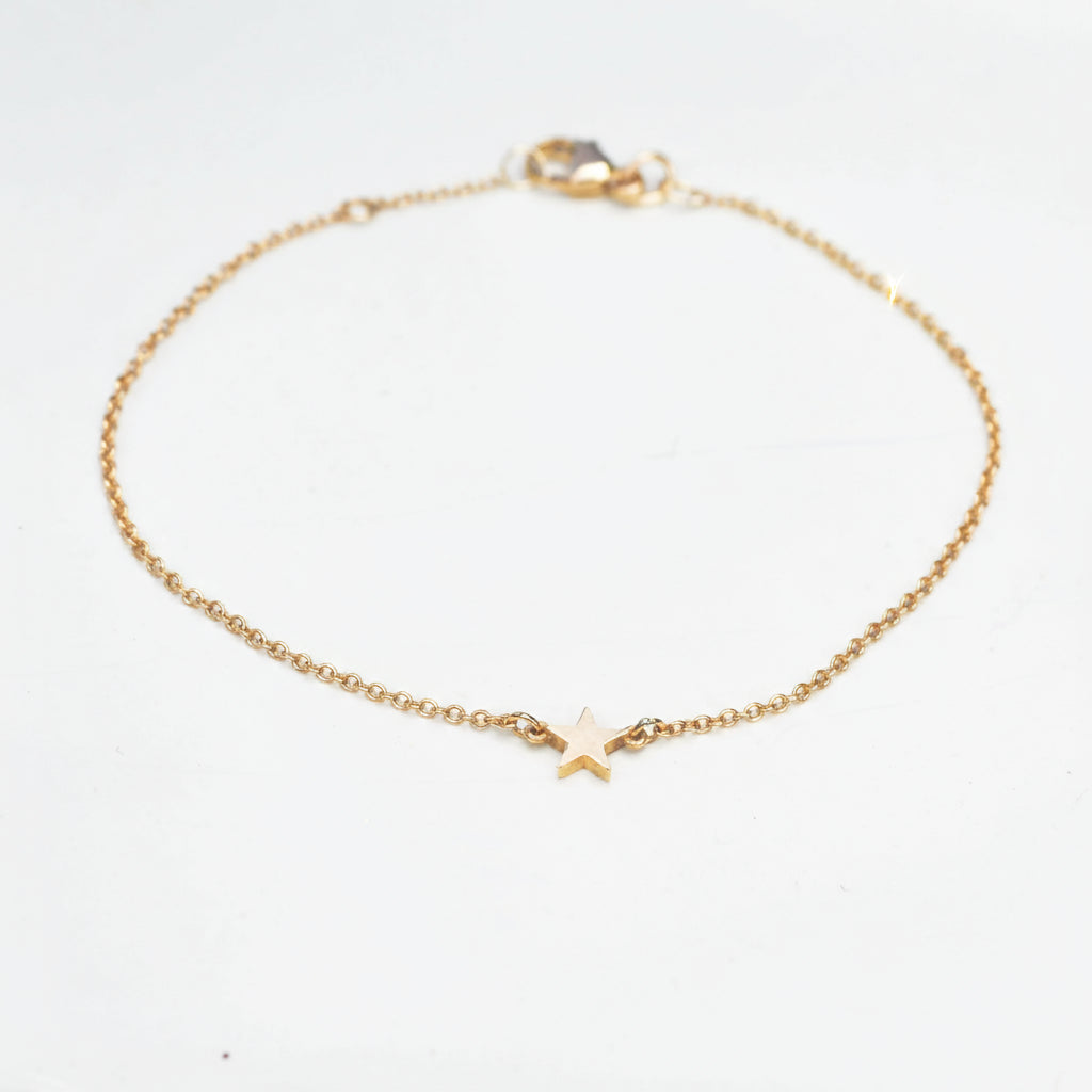 little gold star on a fine trace chain bracelet
