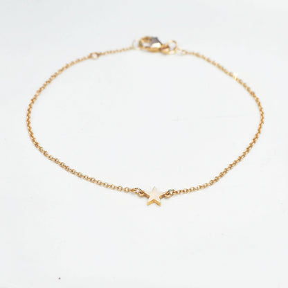 little gold star on a fine trace chain bracelet