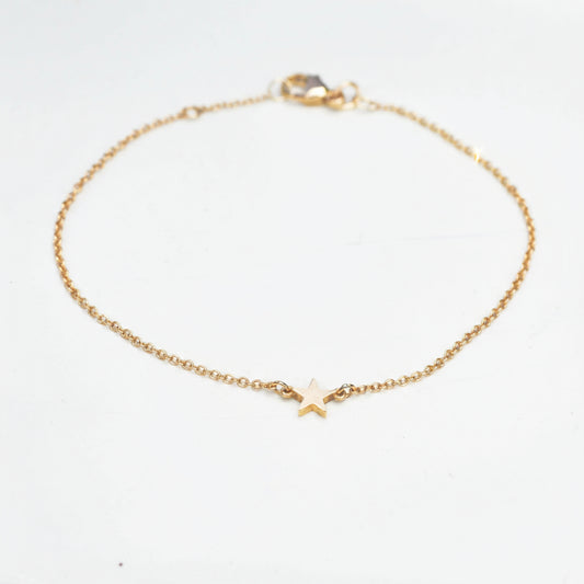 little gold star on a fine trace chain bracelet