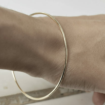 hammered yellow gold fine bangle on wrist
